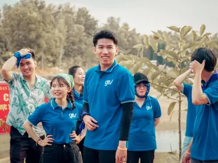 Thành viên GTV SEO mặc áo polo xanh có logo GTV cười sau phần trò chơi ngoài trời