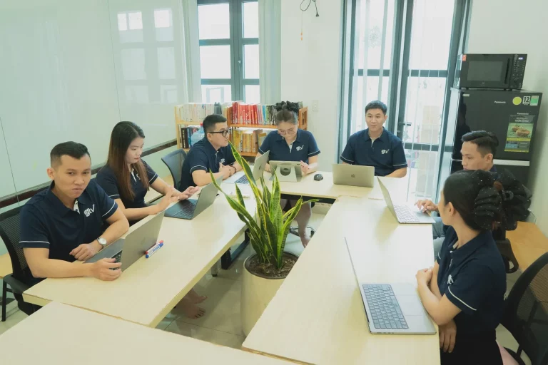 Nhân sự GTV SEO ngồi làm việc với laptop quanh dãy bàn dài trong văn phòng