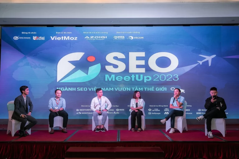 Các diễn giả ngồi trên sân khấu SEO MeetUp 2023, phía sau là màn hình chủ đề Ngành SEO Việt Nam vươn tầm thế giới